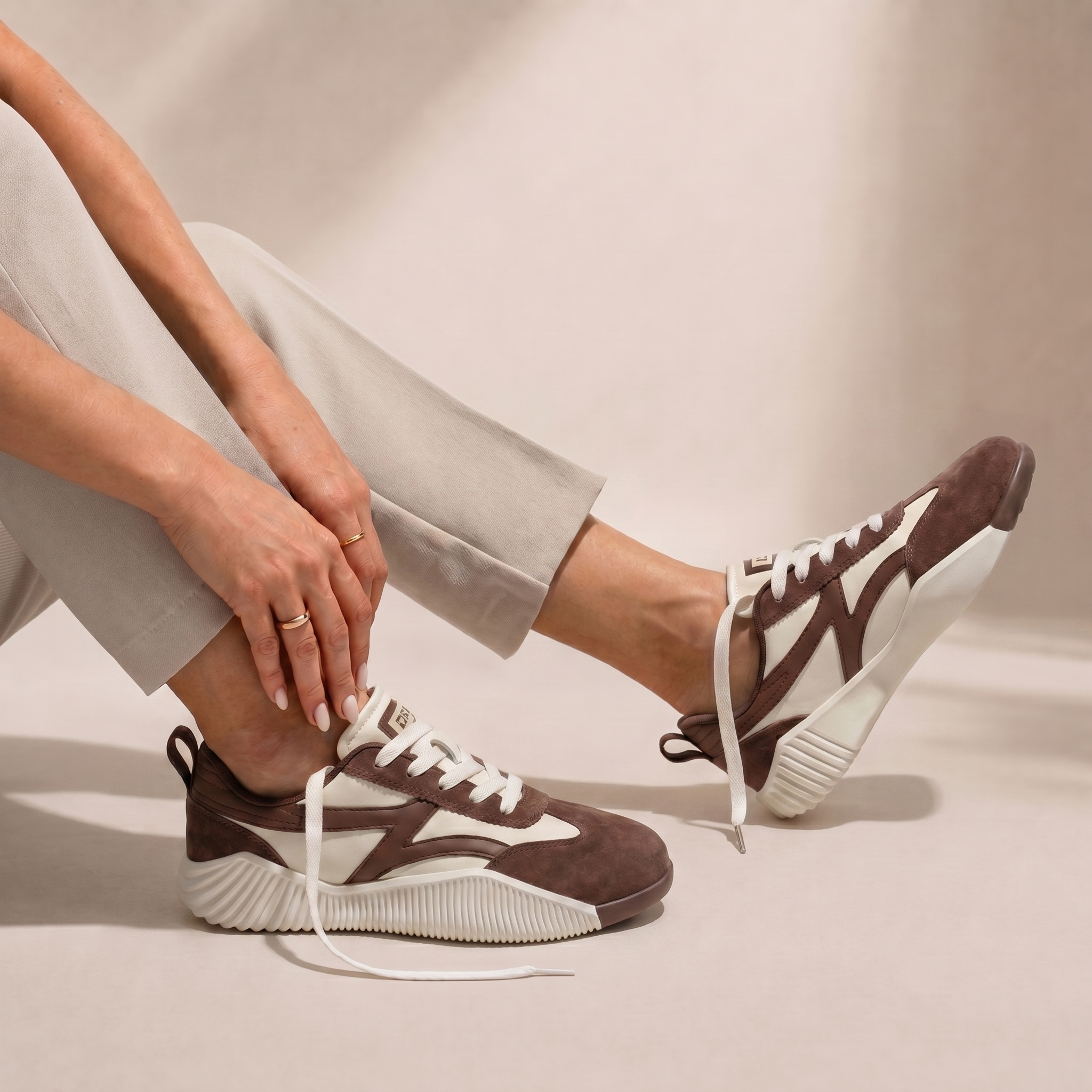 Woman seated wearing DeFlorance Cloudea 2.0 sneakers in Mocha